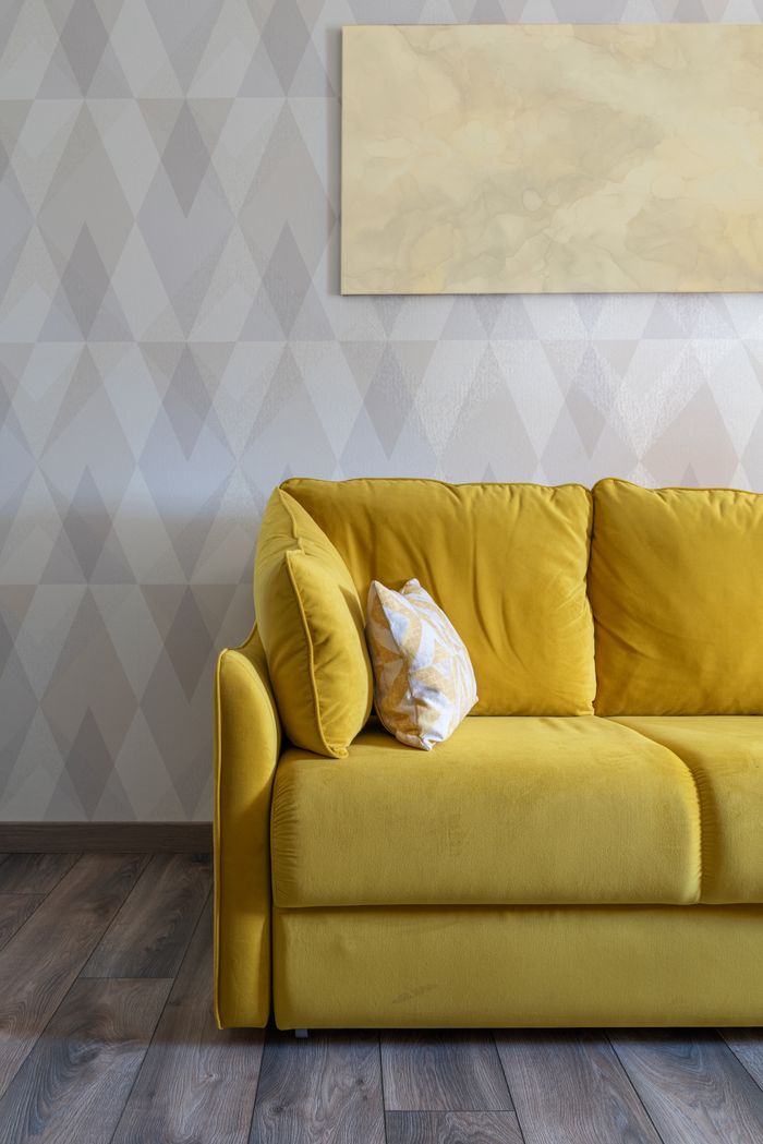 Contemporary living room interior with decorative cushions on couch against wall with rhombic ornament in house